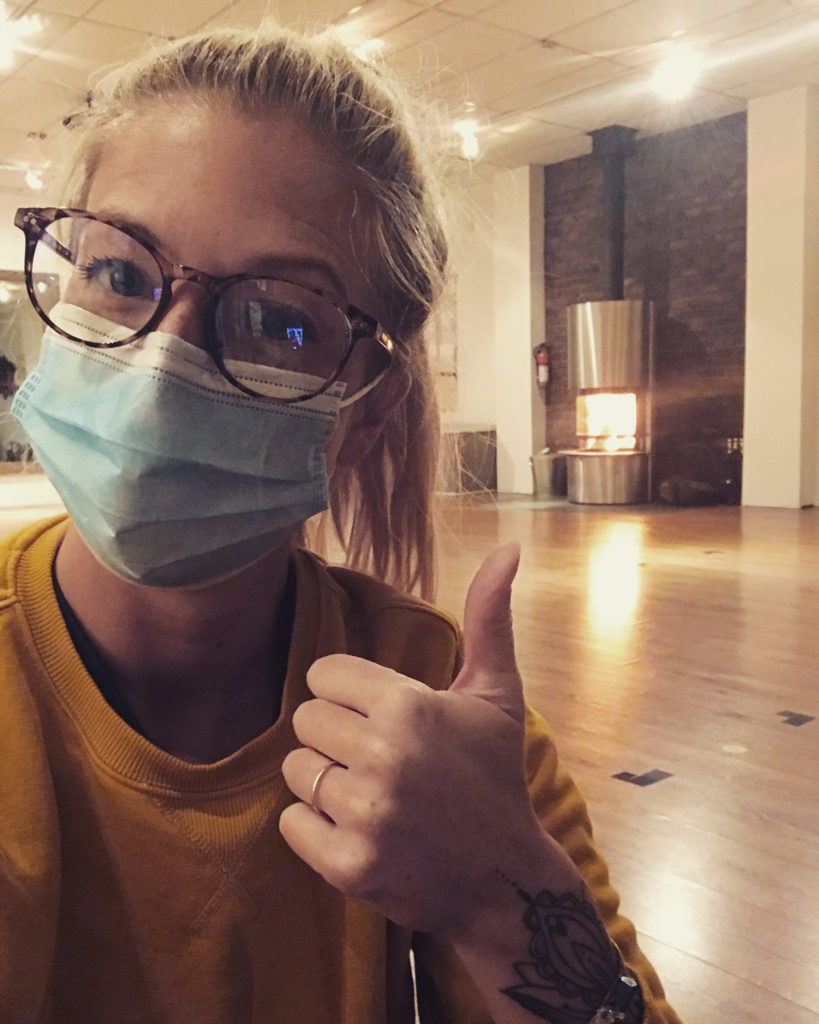 Woman in mask giving thumbs up